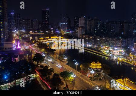 Beleuchtete Stadtgebäude und traditionelle Architektur, die bei Nacht in Chengdu, China, auf dem Fluss jinjiang reflektiert wird Stockfoto