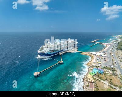 Blick aus der Vogelperspektive auf ein luxuriöses Kreuzfahrtschiff, das auf der Karibikinsel Curacao Willemstad liegt und von türkisfarbenem Wasser umgeben ist Stockfoto