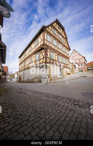 Zwei große Fachwerkhäuser mit rot-weißen Details an einer verkehrsreichen Straßenecke, Oetisheim, Enzkreis, Deutschland Stockfoto