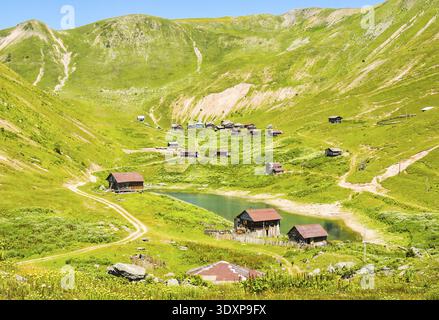Luftaufnahme aus der Ansicht Shuamta kleiner See, umgeben von Bergdorf Holzhäusern im hohen Adjara Stockfoto