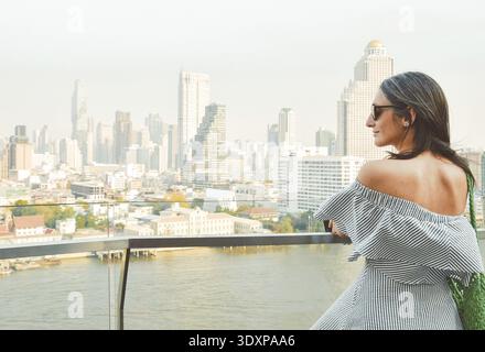 Bangkok, Thailand - 11. februar, 2024: kaukasierin Touristen Genießen Sie Shopping Mall Blick aus berühmten Aussichtspunkt über den Fluss an sonnigen heißen Tagen im Südosten Stockfoto