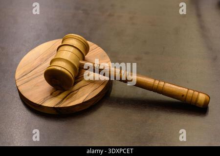 Auf einem runden, hölzernen Schallblock liegt ein Holzhammer. Stockfoto