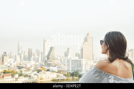 Bangkok, Thailand - 11. februar, 2024: kaukasierin Touristen Genießen Sie Shopping Mall Blick aus berühmten Aussichtspunkt über den Fluss an sonnigen heißen Tagen im Südosten Stockfoto