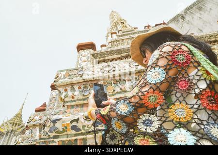 Junge Reisende Bloggerin, die Fotos Videos des wunderschönen buddhistischen Tempels Wat Arun macht - berühmtes Reiseziel in Bangkok, Thailand. Touristenseufzen Stockfoto