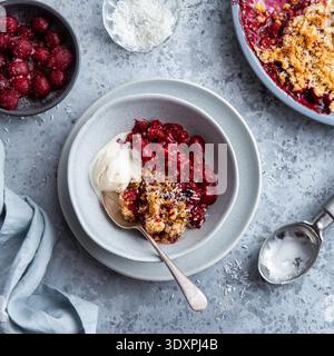 Köstlicher Kirschkrümelkuchen serviert mit Vanilleeis in der Schüssel, Blick von oben, quadratisches Bild Stockfoto