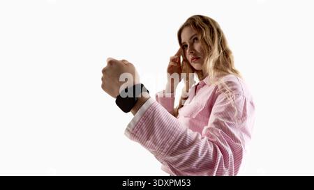 Junge Frau, die Smartwatch auf weißem Hintergrund trägt. Stockfoto