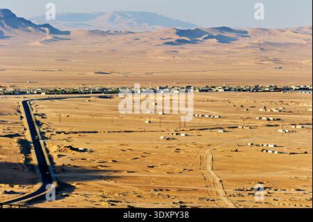 Die neue Stadt Palmyra in Syrien mit einer weiten Landschaft, Straßen und fernen Bergen unter klarem Himmel während des Tages aus der Luft. Stockfoto