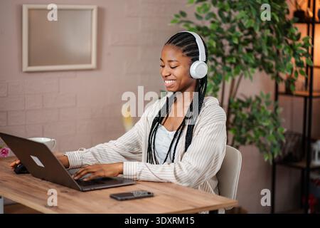 Junge schwarze Frau aus der Ferne, die vom Heimbüro aus arbeitet Stockfoto