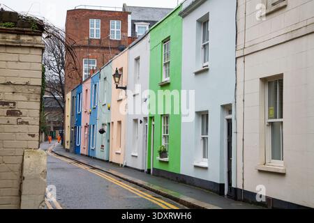 Eine Reihe von bunten Reihenhäusern in einem Kensington-Miws, London. Charmante, enge Wohnstraße mit pastellfarbenen Fassaden und klassischer britischer Architektur Stockfoto