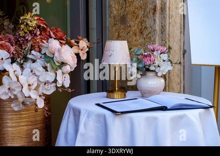 Dekorierter Kaffeetisch mit Blumenarrangements und Menü. Gehobenes Dining-Konzept, Hochzeitsempfang und elegantes Gastfreundschaftsthema. Stockfoto