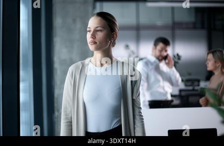 Eine Frau steht vor einem Mann, der auf einem Handy spricht Stockfoto