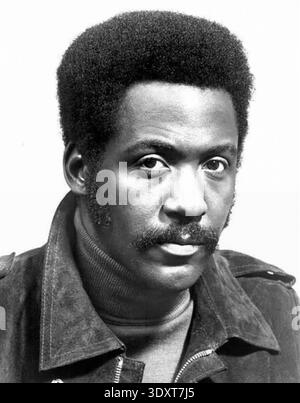 Dieses Werbefoto aus den 1970er Jahren zeigt ein beeindruckendes Porträt von Richard Roundtree als seiner ikonischen Figur John Shaft. Roundtree, bekannt für seine Darstellung des stilvollen Detektivs, wird hier mit seinem unverwechselbaren Schnurrbart und Afrofrisur dargestellt, der einen Rollkragen und eine Lederjacke trägt und die kühle Blaxploitation-Ästhetik der Epoche verkörpert. Stockfoto