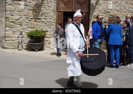 Mitglied einer religiösen Bruderschaft, die während der Karfreitagsprozession in Corleone, Sizilien, Italien, trommelspielt. Stockfoto