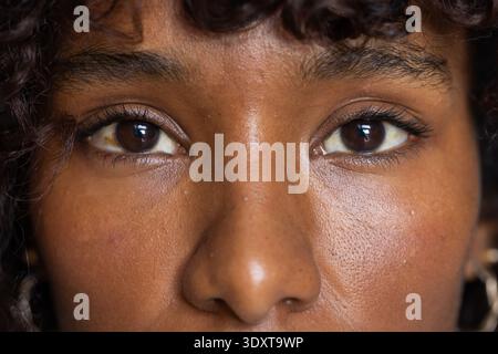 Afroamerikanerin fokussiert auf Augen Nase mit lockigem Haar und goldenem Korb in Atelier-Nahaufnahme Stockfoto