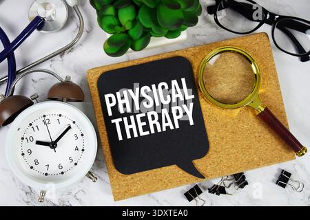 Physiotherapietext mit Wecker, Taschenrechner und Stethoskop auf Marmorhintergrund Stockfoto
