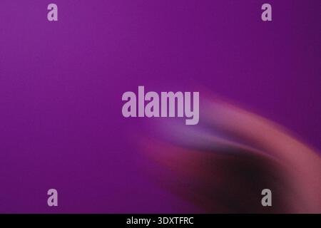 Ein verschwommenes Bild mit einer Hand, die vor einem massiven violetten Hintergrund reicht, sorgt für ein weiches ästhetisches Aussehen Stockfoto