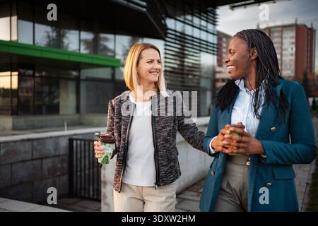Verschiedene Geschäftspartner laufen und unterhalten sich während der Kaffeepause Stockfoto
