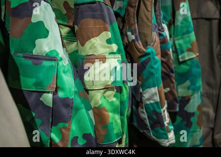 Tarnung von grünen und braunen Militäruniformen in einem Lagerhaus Stockfoto