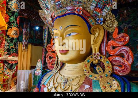 Detaillierter Blick auf das ruhige Gesicht der goldenen Maitreya Buddha Statue in Thiksey Gompa mit einer komplizierten Krone und schwerem Schmuck. Stockfoto