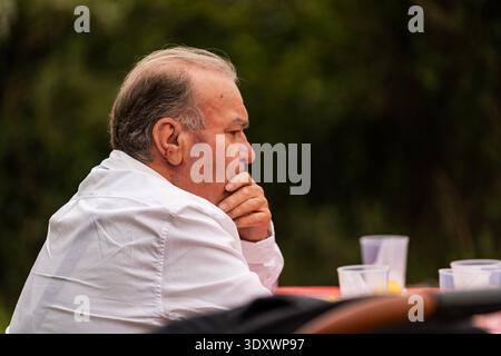 Senior-Mann mit Hand am Kinn, der wegblickt, tief nachdenklich Stockfoto