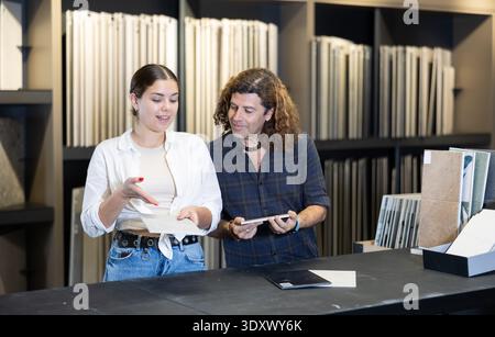 Ehemann und Ehefrau wählen Keramikfliesen für die Küchenverkleidung im neuen Haus Stockfoto
