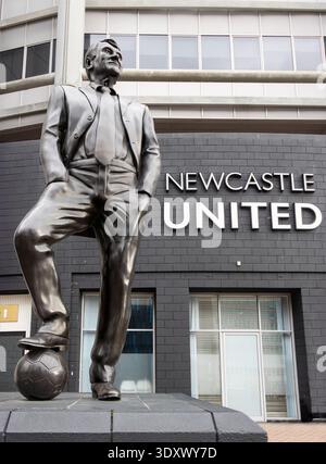 Bronzestatue des Fußballmanagers Bobby Robson vor dem Eingang des Newcastle United Stadions mit seinem Fuß auf einem Football St. james Park Stockfoto