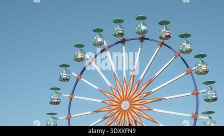 Riesenrad mit dekorativem Sonnenschliff und farbenfrohen Gondeln im Vergnügungspark im historischen Buchara, Usbekistan. Stockfoto