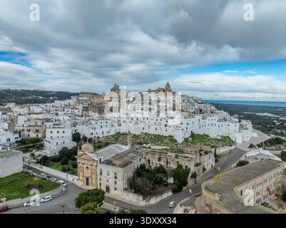 Atemberaubende Luftperspektive von Ostuni, Italien. Ein perfekter Blick auf Apuliens Weiße Stadt, eingebettet zwischen Olivenhainen über der glitzernden Adria Stockfoto