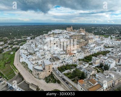 Atemberaubende Luftperspektive von Ostuni, Italien. Ein perfekter Blick auf Apuliens Weiße Stadt, eingebettet zwischen Olivenhainen über der glitzernden Adria Stockfoto