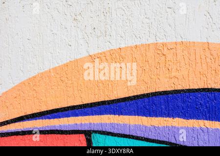 Bunte abstrakte Straßenkunst mit orangefarbenen, blauen, pfirsichfarbenen, türkisfarbenen und schwarzen Linien auf der weißen Wand Stockfoto