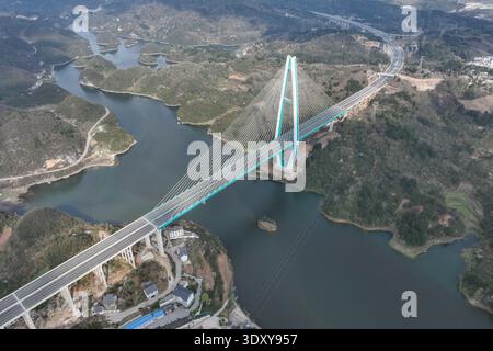 Guiyang, China. 4. März 2026. Die Luftaufnahme nahm am 4. März 2026 die Baihua Lake Bridge ein, eine wichtige Komponente des Erweiterungsprojekts für den Abschnitt Guiyang-Anshun des Shanghai-Kunming National Expressway. Die Brücke befindet sich an der Grenze zwischen dem Bezirk Guanshanhu der Stadt Guiyang und der Stadt Qingzhen in der Provinz Guizhou und überspannt den Baihua-See. Mit einer Gesamtlänge von 1.086 Metern, einer Breite des Hauptdecks von 36,5 Metern und einer Höhe des Hauptturms von 219 Metern ist sie die größte Hybrid-Träger-Single-Pylon-Seilbrücke ihrer Art in der Provinz Guizhou. Derzeit ist die Hauptstruktur o Stockfoto