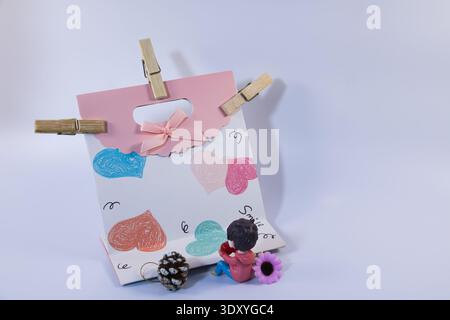 Niedliche dekorative Geschenktasche mit bunten handgezeichneten Herzen, kleiner Figur und Ornamenten. Romantisches Liebeskonzept zum Valentinstag, Beziehung, Begrüßung Stockfoto