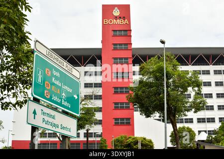 Putrajaya, Malaysia - 15. November 2025: Malaysisches BOMBA-Hauptquartier mit Autobahnschildern nach Ipoh, Kuala Lumpur, KLIA, Johor Bahru und Putra Stockfoto