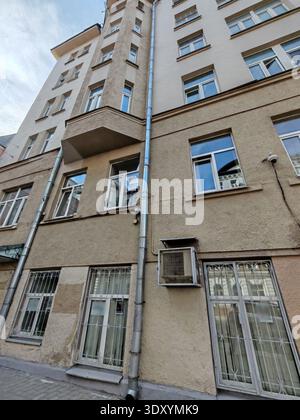 Ein historisches mehrstöckiges Gebäude mit einer Mischung aus Ziegelstein und weißem Putz, mit einer dekorativen Statue und verzierten Details. Das Gebäude Stockfoto