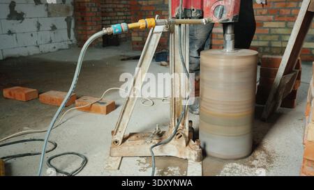 Der leistungsstarke Bohrer mit Diamantspitze bohrt Löcher für die Kommunikation im Haus Stockfoto