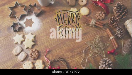 Weihnachtsgebäck auf Holztisch arrangieren, Kekse zeigen, Metallsternschneider handgeschrieben MERRY Christ Stockfoto