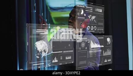 Interagierender Mann in hellgrauem Hoodie mit holografischen Panels im Servergang mit LED-Beleuchtung Stockfoto