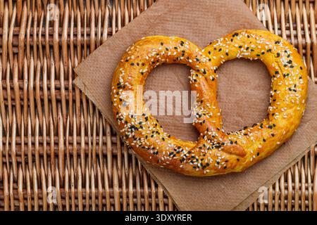Frisch gebackene hausgemachte Brezel mit schwarz-weißen Sesamsamen. Deutsche (bayerische) Biervorspeise. Traditionelles herzhaftes Gebäck. Selektiver Fokus Stockfoto