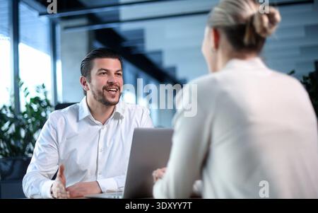 Ein Mann und eine Frau sitzen am Tisch und reden Stockfoto
