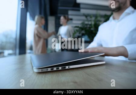 Ein Mann sitzt an einem Schreibtisch mit offenem Laptop Stockfoto