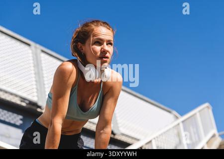 Aktive Frau, die sich nach dem Joggen im Freien ausruht Stockfoto