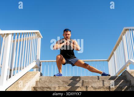Fitter Mann, der im Sommer im Freien in urbaner Umgebung Sport treibt. Stockfoto