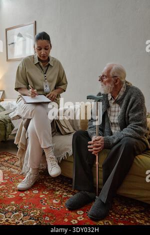 Junge Erwachsene Schwarze Sozialarbeiterin Interviewt Einen Älteren Kaukasischen Mann Stockfoto