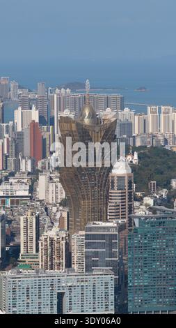 Majestätisch erhebt sich das goldene Grand Lisboa Hotel aus der Vogelperspektive inmitten eines Meeres von Gebäuden, die das Sonnenlicht einfangen, Macau, Macao. Stockfoto