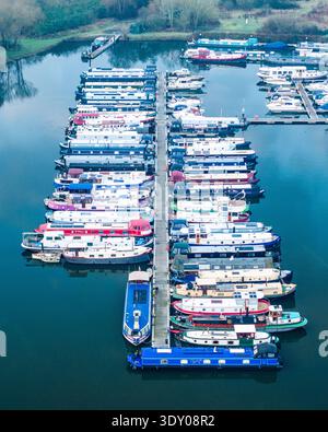Blick aus der Vogelperspektive auf einen lebendigen Yachthafen voller farbenfroher Hausboote, die ordentlich angedockt sind und sich auf das ruhige Wasser der Themse, Reading, Berkshire, UN reflektieren Stockfoto