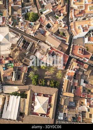 Blick aus der Vogelperspektive auf sonnendurchflutete Dächer und enge Gassen, die lange Schatten über die alte Mezquita-Kathedrale und Alcázar de los Reyes Cristianos, Có werfen Stockfoto