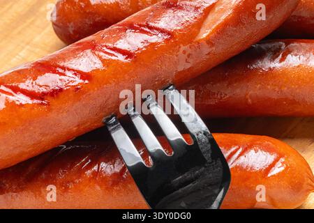 Appetitliche gegrillte Würstchen auf einem Schneidebrett aus nächster Nähe Stockfoto