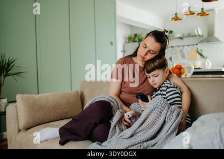 Mom besprüht die Nase des Jungen mit Nasenspray Stockfoto