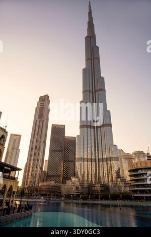 Ein vertikales, flaches Foto, das den Burj Khalifa und die umliegenden Wolkenkratzer in der Innenstadt von Dubai während des Sonnenuntergangs einfängt. Der massive Silberglasstru Stockfoto