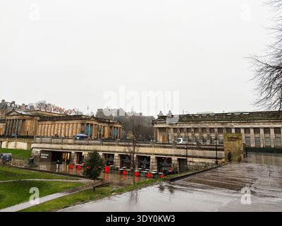 Edinburgh, Schottland, Großbritannien - 15. Februar 2026: Feuchte Regenszene in der Edinburgh National Gallery mit neoklassizistischen Fassaden, Besuchern und Edinburgh Castle Stockfoto